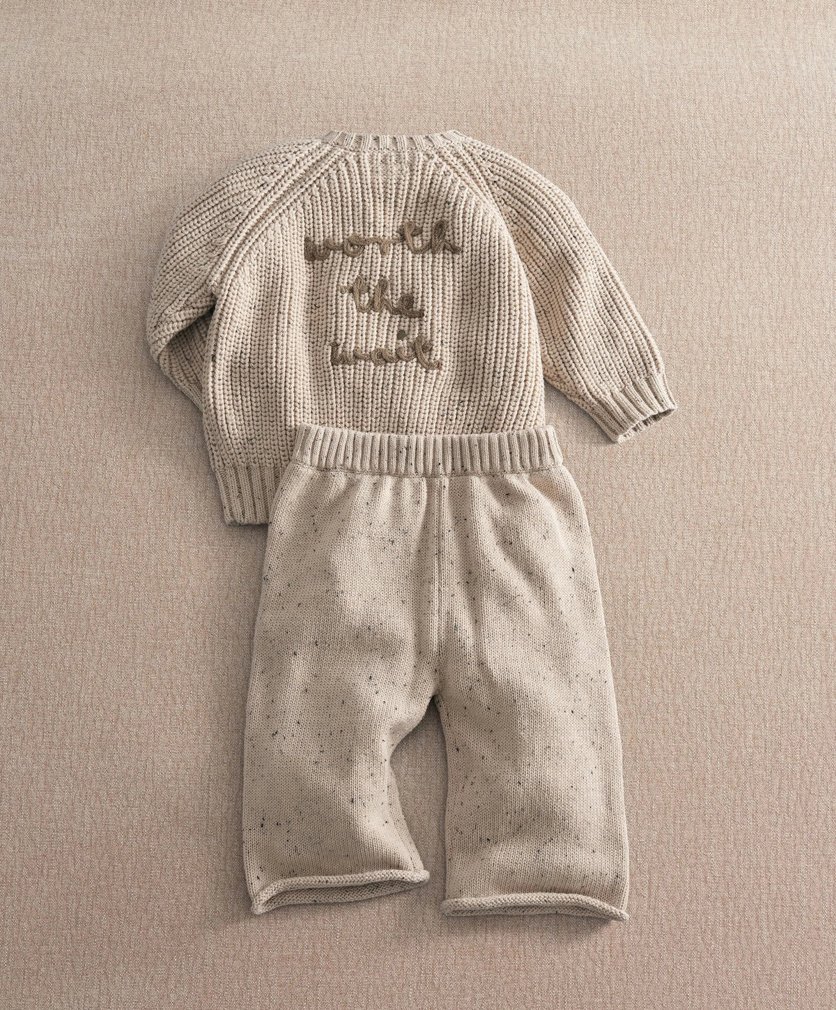 Cream knitted baby set with long-sleeve snail applique top and speckled pants