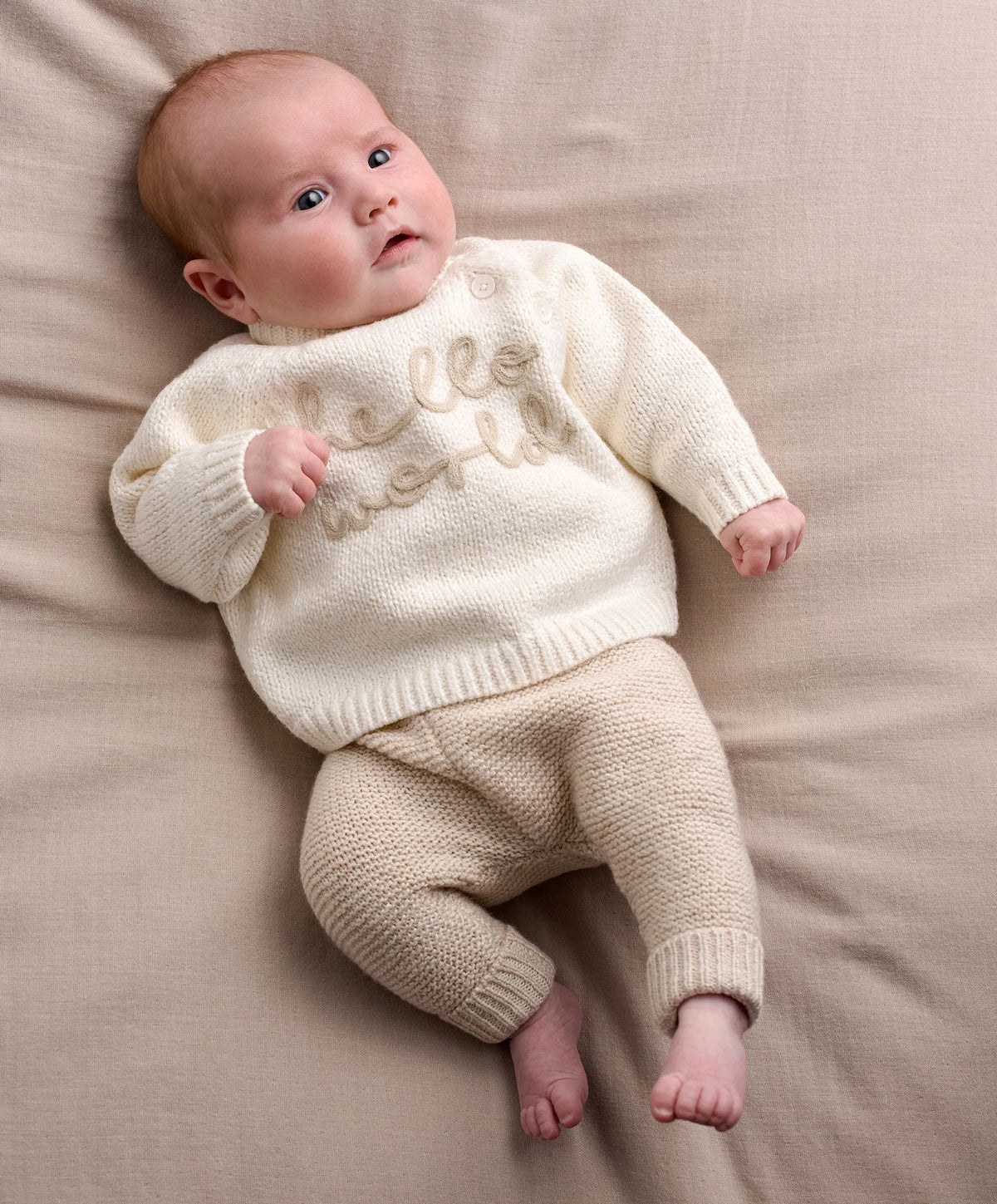 Cream knit 2-piece baby set with long-sleeve top and pants, 'hello world' embroidery.