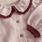 Light pink knit cardigan top with button placket, maroon collar and cuffs