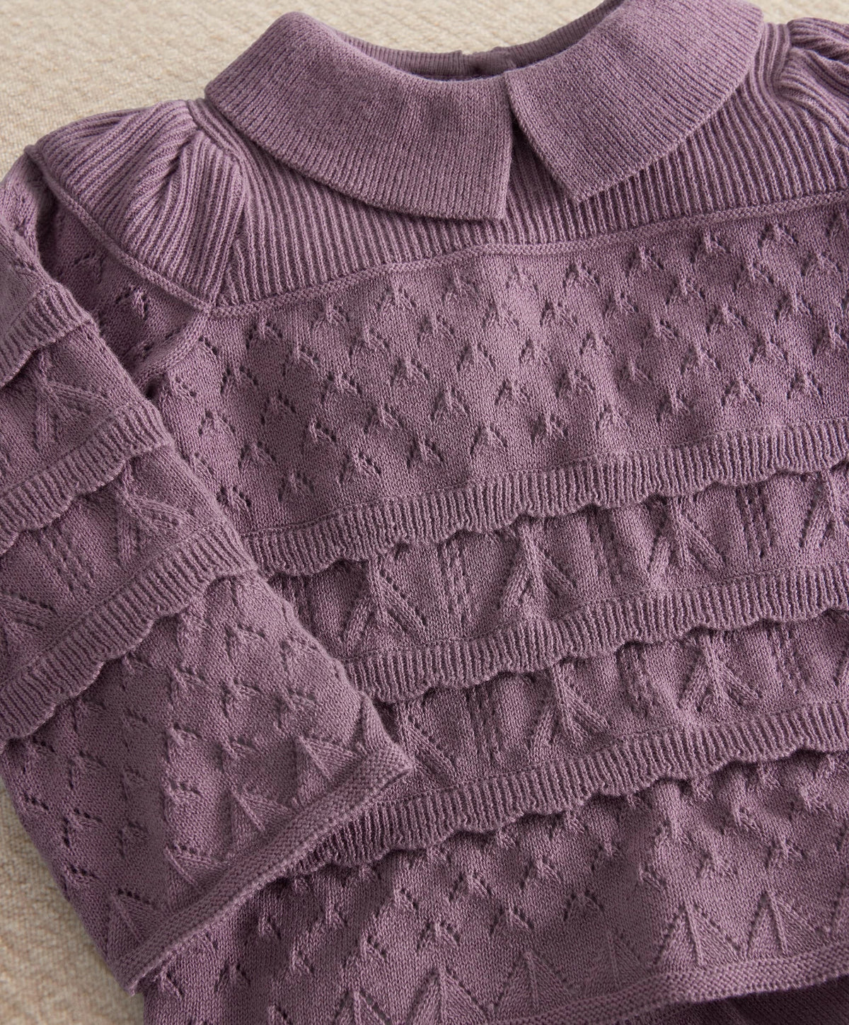Plum knit sweater top with textured pattern and layered ruffle detail