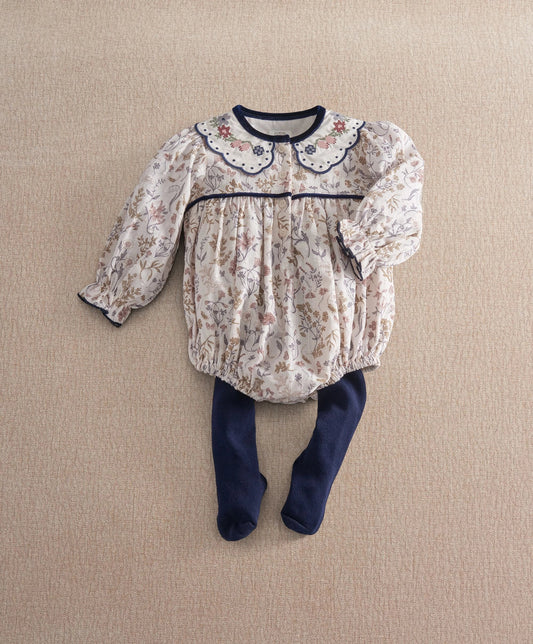 Floral romper with long sleeves, scalloped navy collar, and navy tights