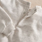 Light gray sweatshirt with ribbed collar and cuff, snap-button placket detail