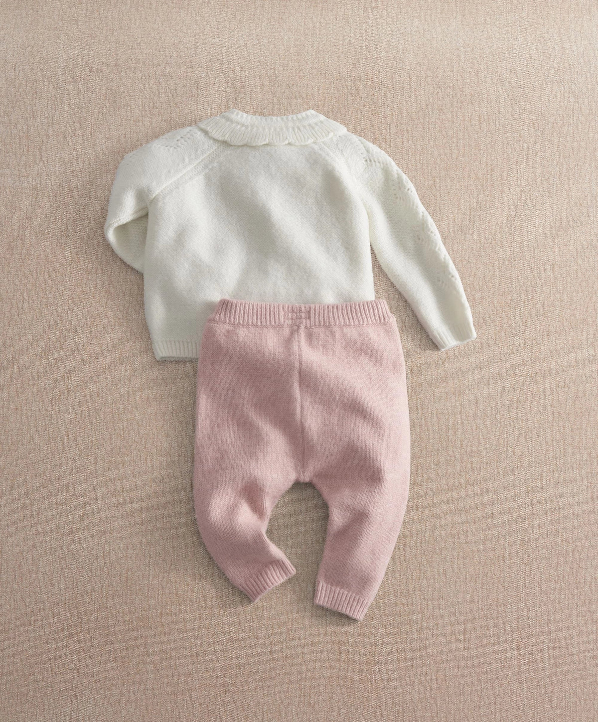 Back view of cream knit cardigan and mauve knit leggings set with ribbed cuffs.