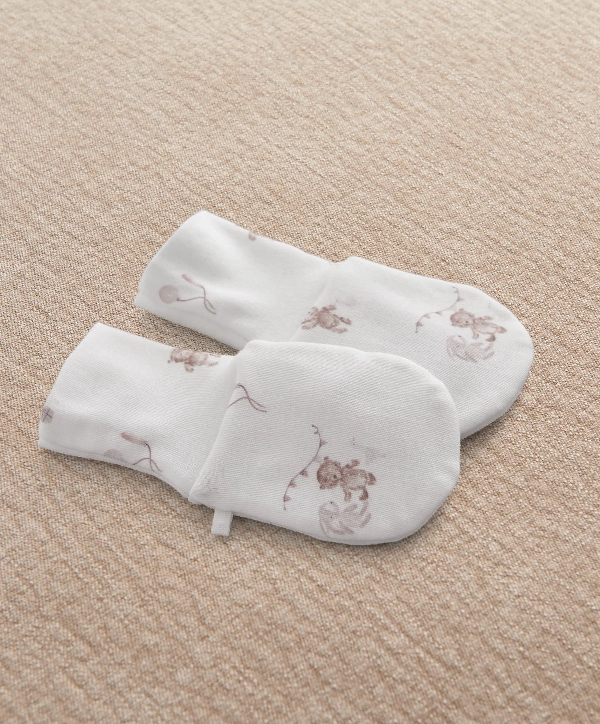 White printed baby mittens with whimsical animal motifs