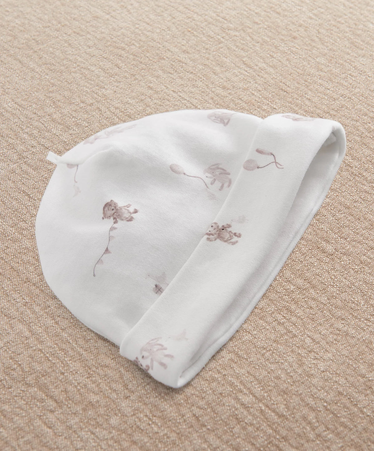 White printed baby hat with whimsical animal motifs