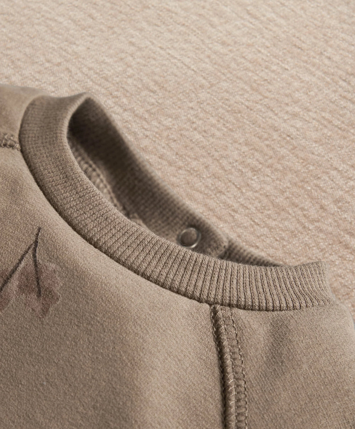 Gray romper neckline with ribbed trim and small button at the back
