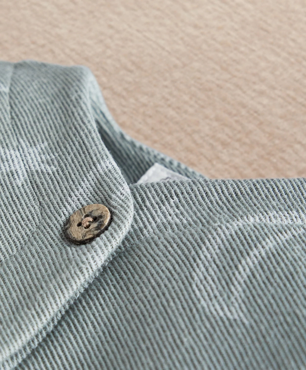 Light blue romper shoulder with stitched collar and round wooden-look button