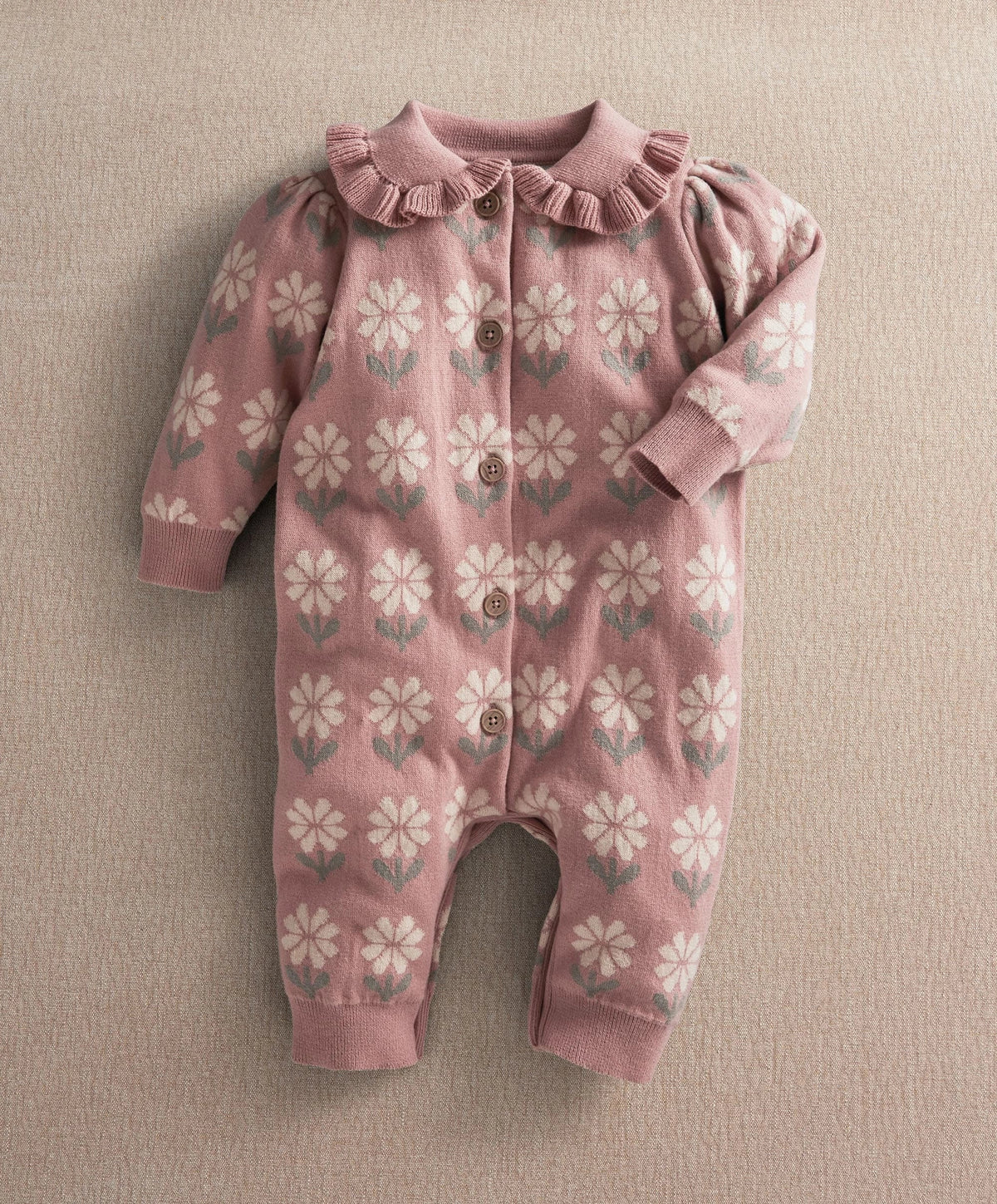Pink floral knitted baby romper with long sleeves and button placket