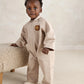Light tan zip-front romper with turn-down collar, bear patch, and front patch pockets
