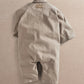 Light tan oversized boiler suit romper with short sleeves and front flap pockets