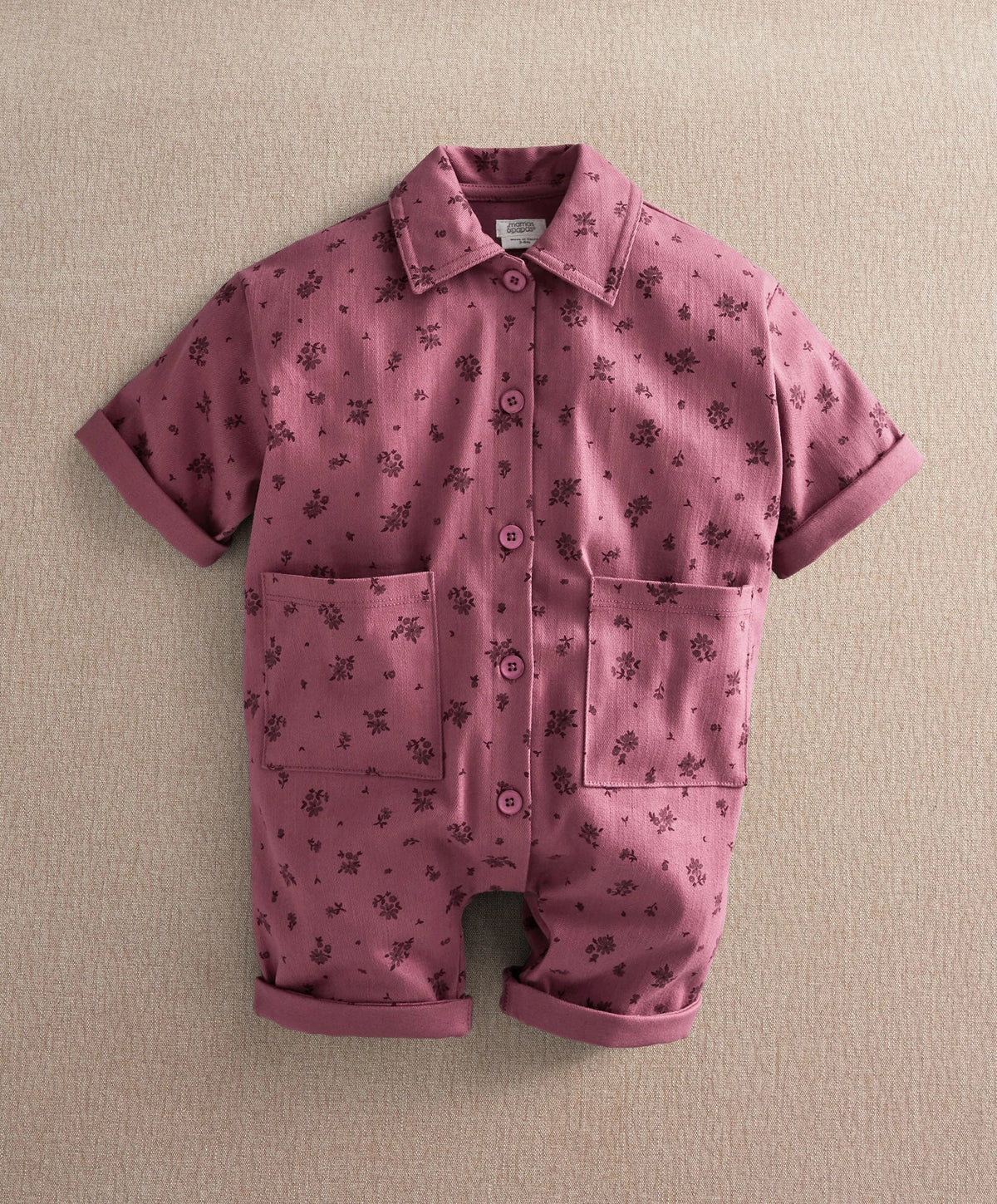 Purple floral short-sleeve romper with button front and two chest patch pockets