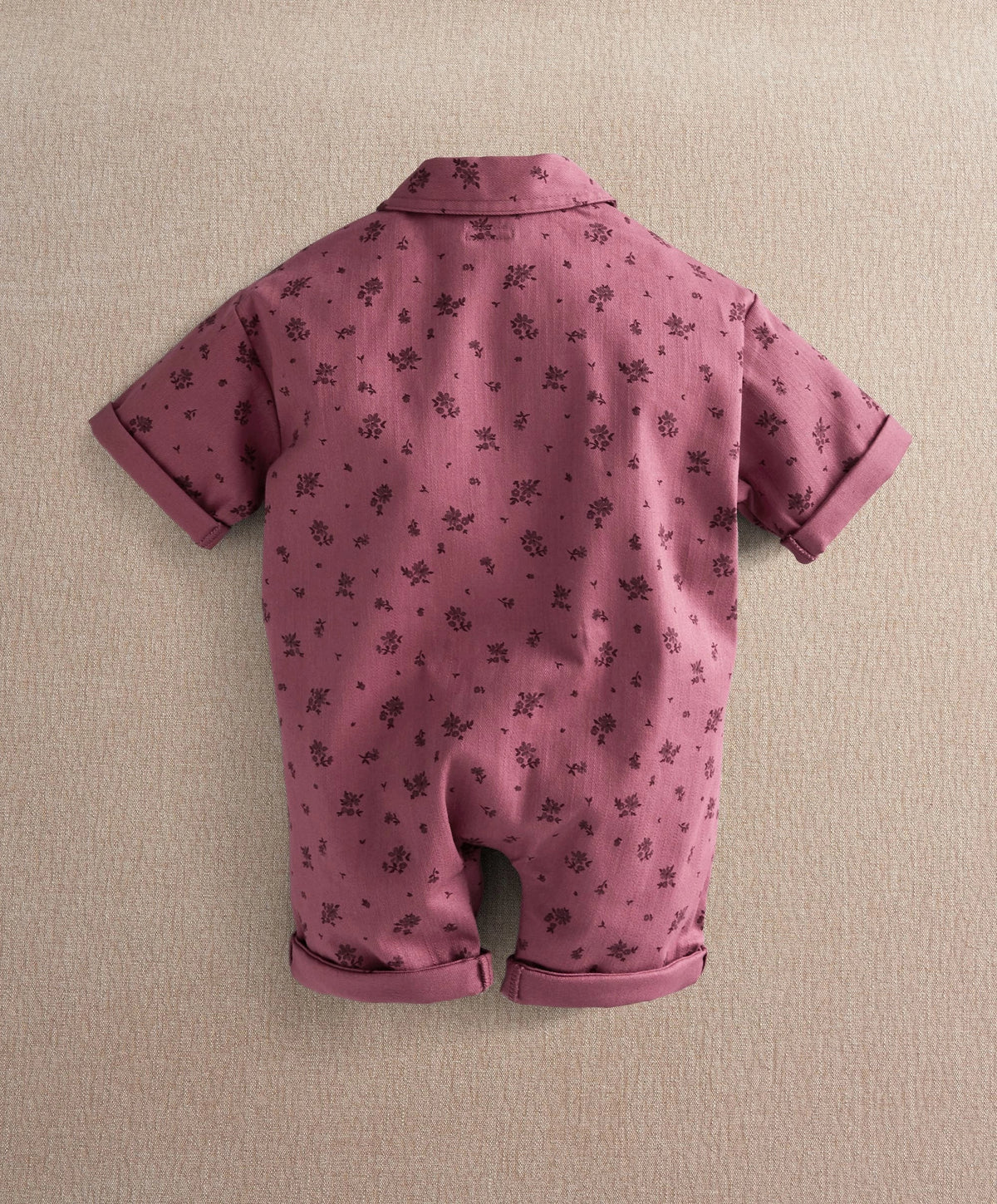 Purple floral short-sleeve romper, back view with collar and cuffed legs