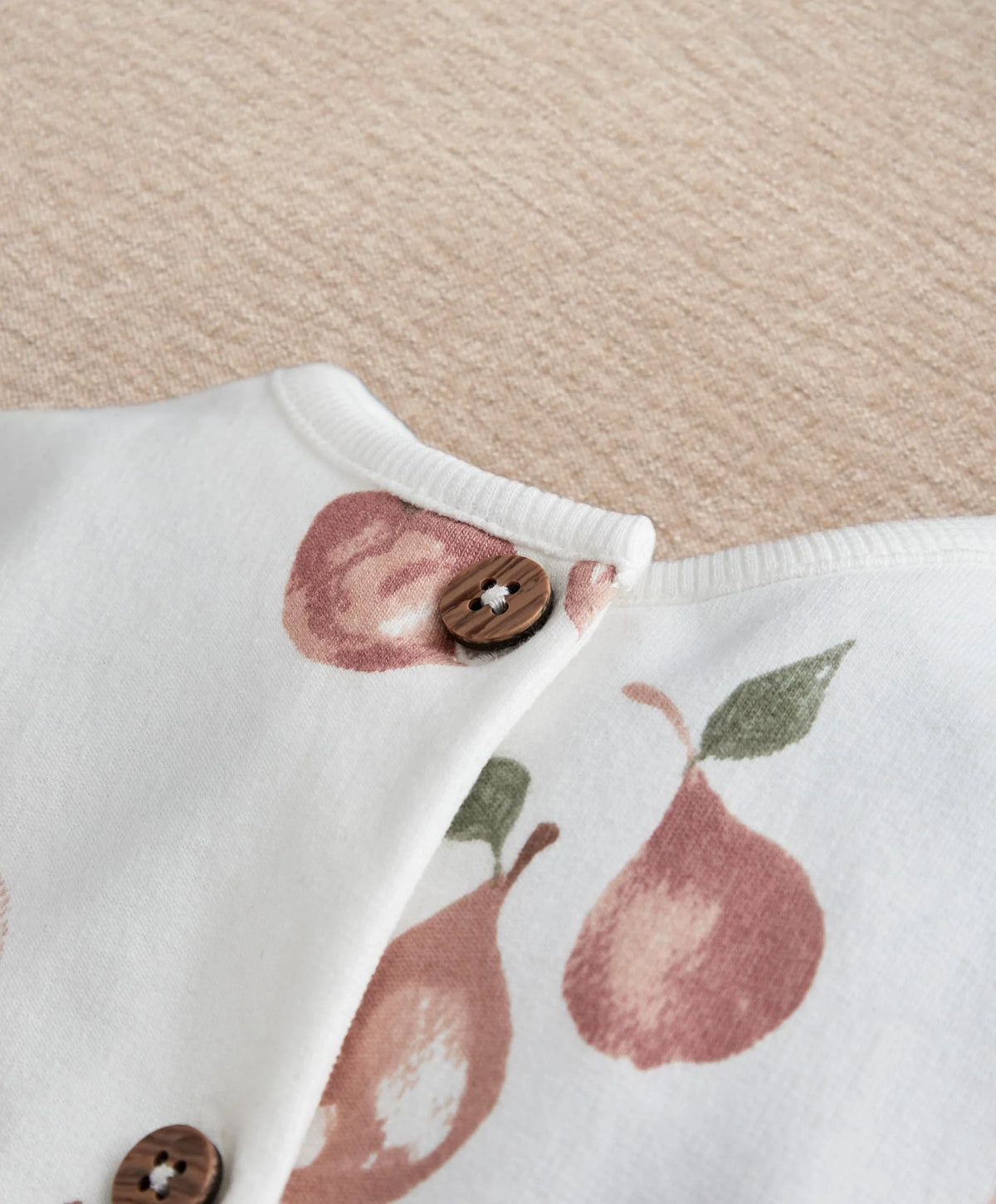 White fruit-print romper neckline with snap closure and leaf graphic