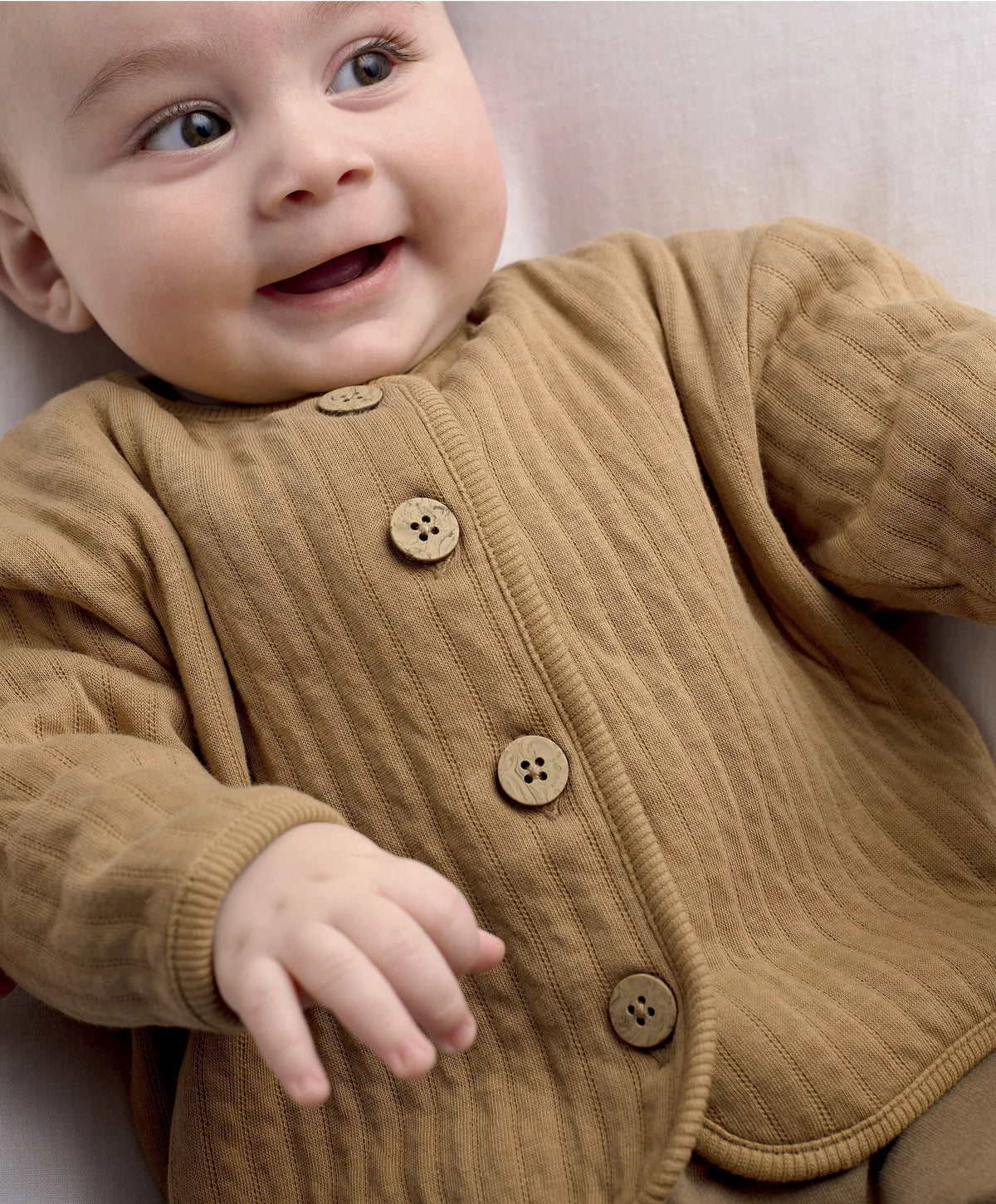 Tan jacket with button placket and small snail embroidery at chest
