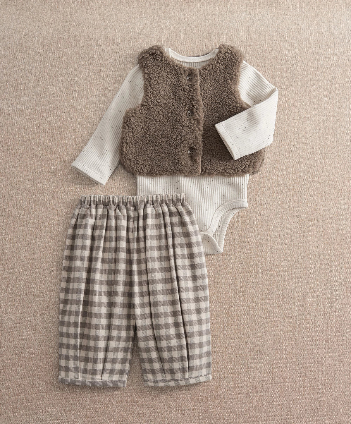 Brown borg vest with white bodysuit and gray plaid trousers outfit