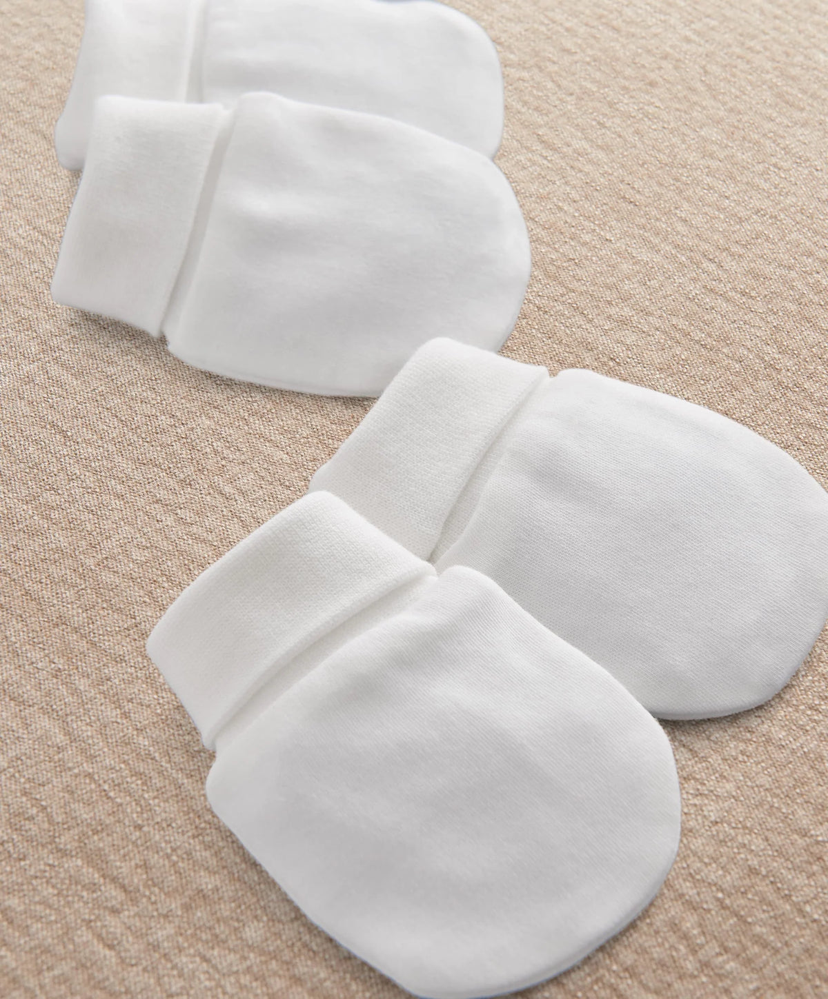 White scratch mittens with wide cuffs, two-pack laid flat