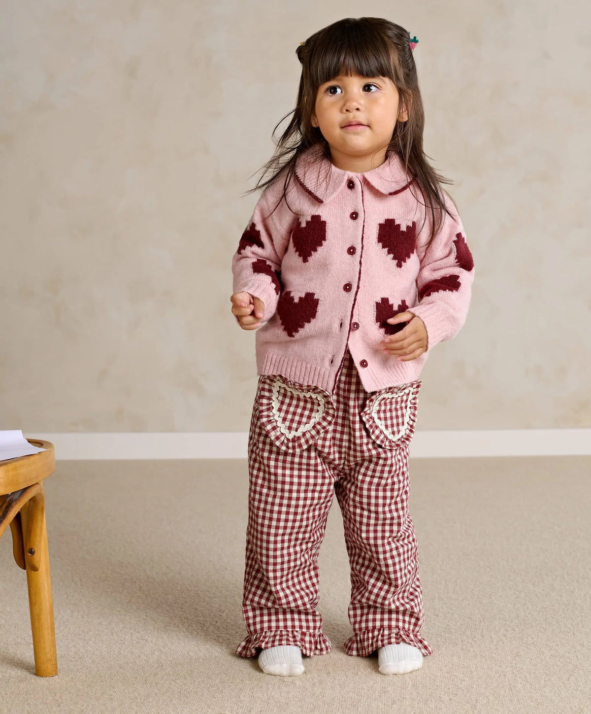 Pink heart cardigan with dark red button front and ribbed cuffs, full outfit view