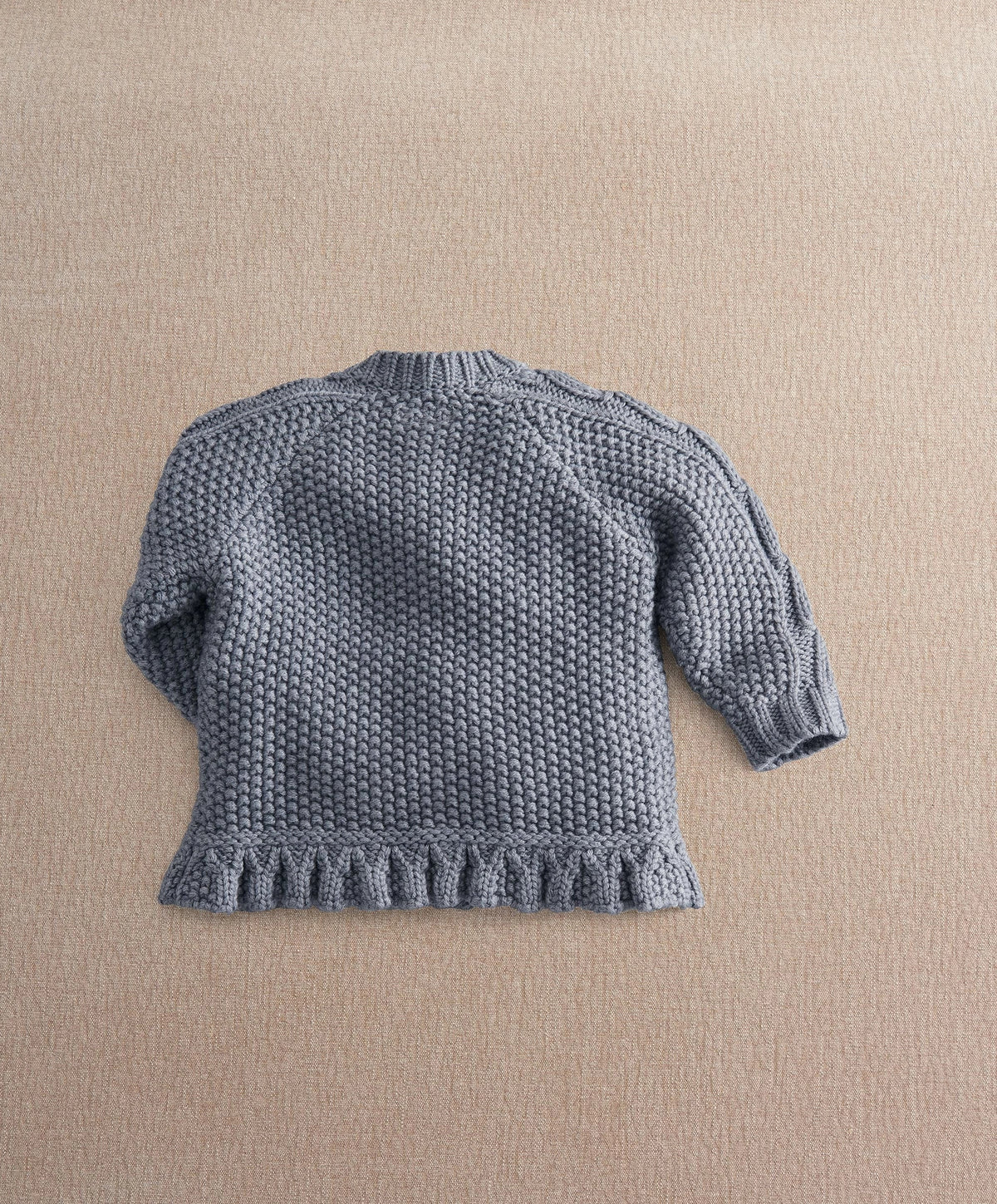 Gray knit cardigan back view with ribbed cuffs and textured hem