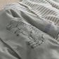 Baby sleepsuit close-up in grey with dinosaur print and ROAR text