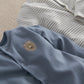 Light blue romper with embroidered lion patch and snap buttons