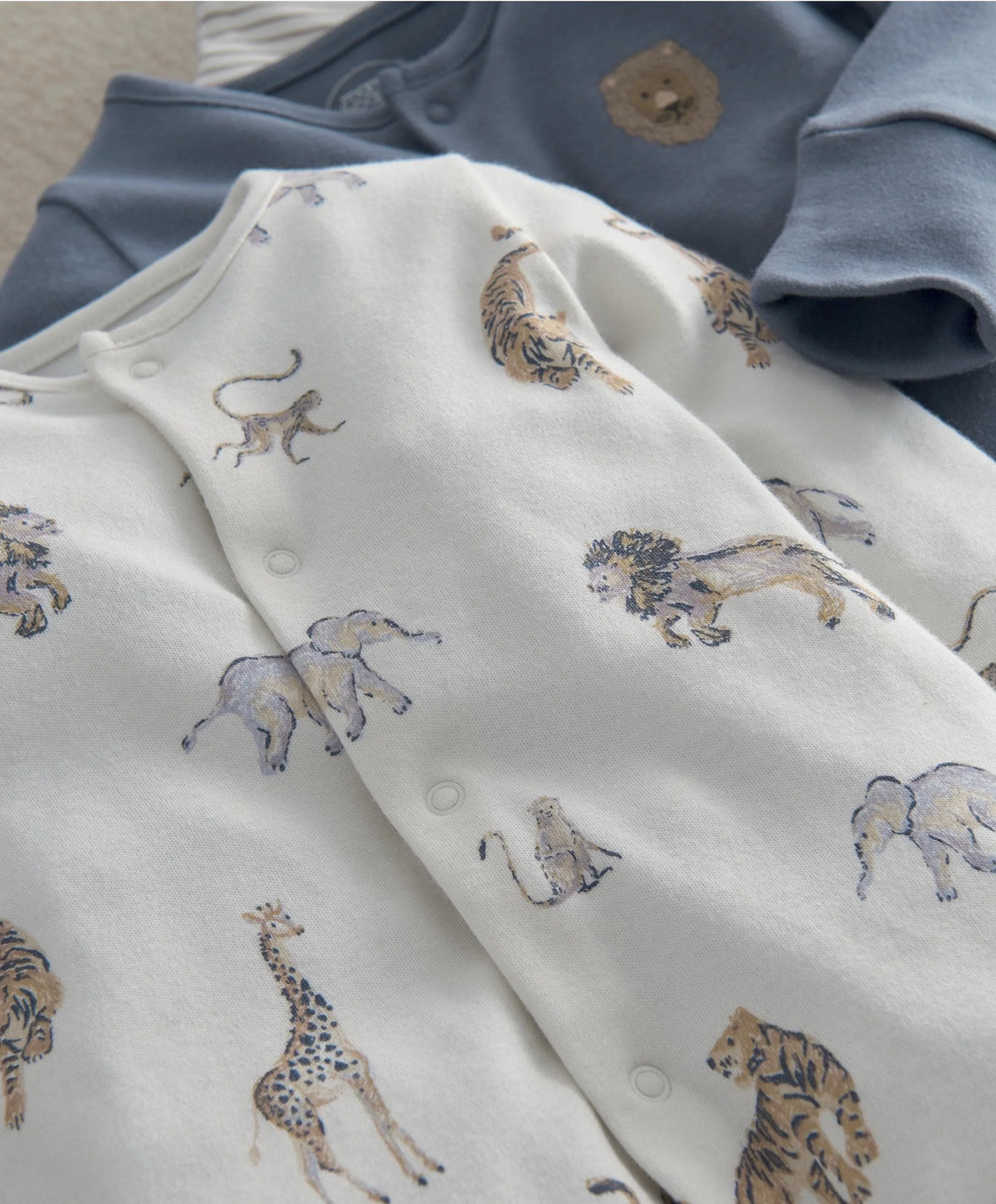White safari animal-print romper with snaps and long sleeves
