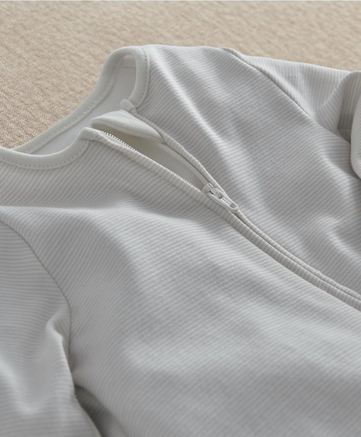White zip-front sleepsuit with long sleeves and covered foot cuffs