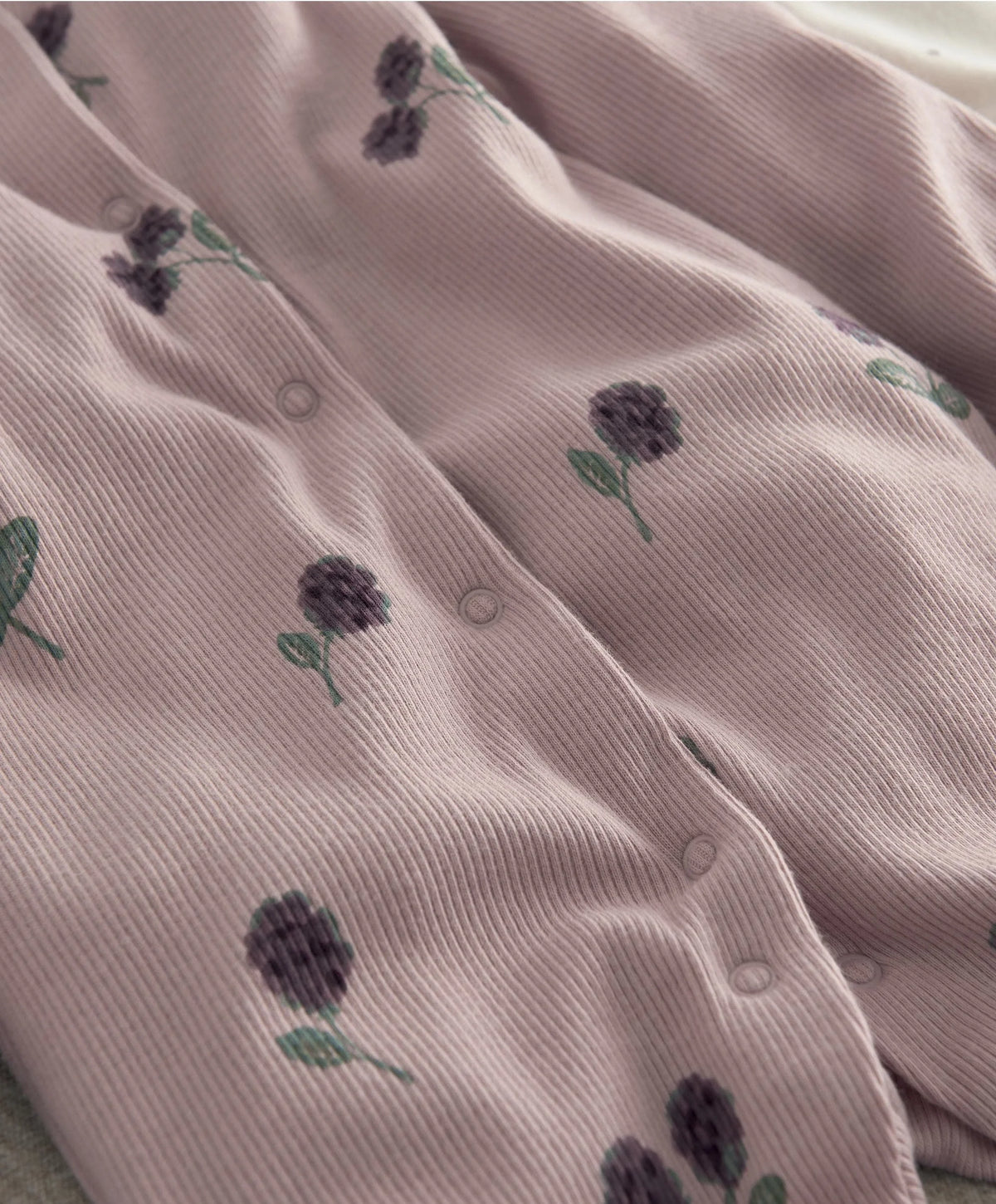 Blush floral baby sleepsuit with button placket and long sleeves