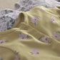 Yellow floral baby romper with snap placket and gathered neckline detail