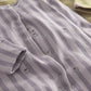 Lavender striped baby romper close-up with button placket and small floral print