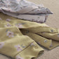 Folded baby rompers with floral fabric and snap buttons at leg opening