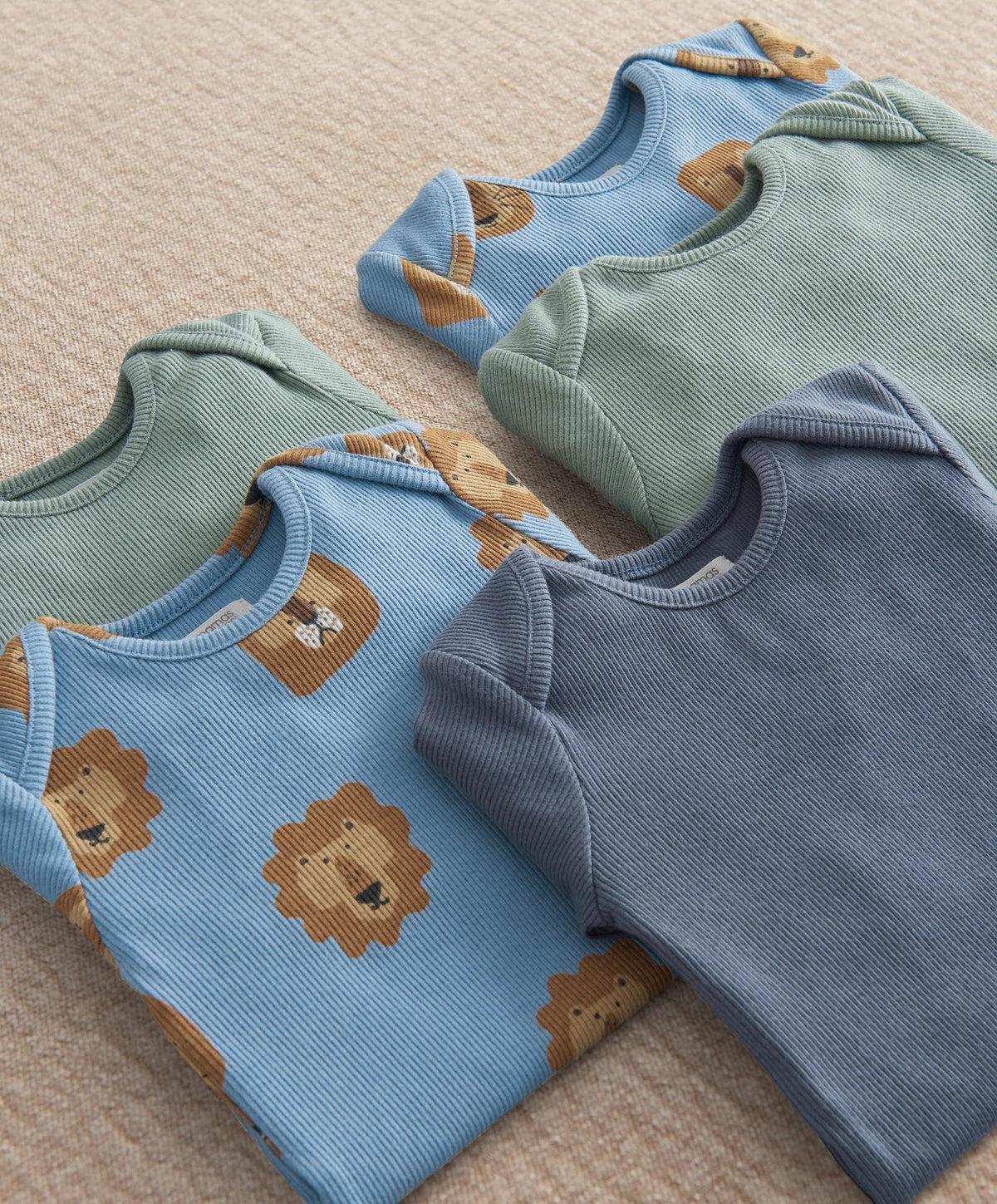 Pack of 5 lion-print bodysuits, overlapping close-up: light blue, mint, navy