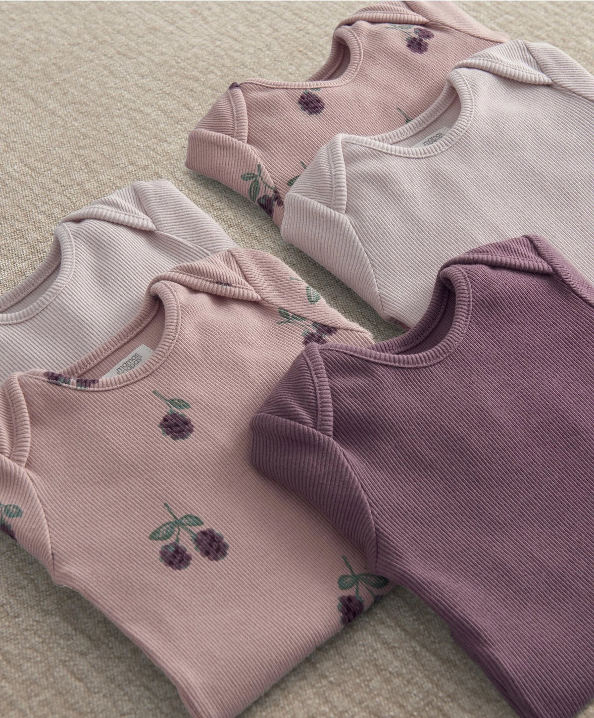Baby bodysuit set close-up: ribbed light pink and plum purple with berry print