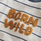 Close-up of striped T-shirt with fuzzy 'Born Wild' embroidered-style letters