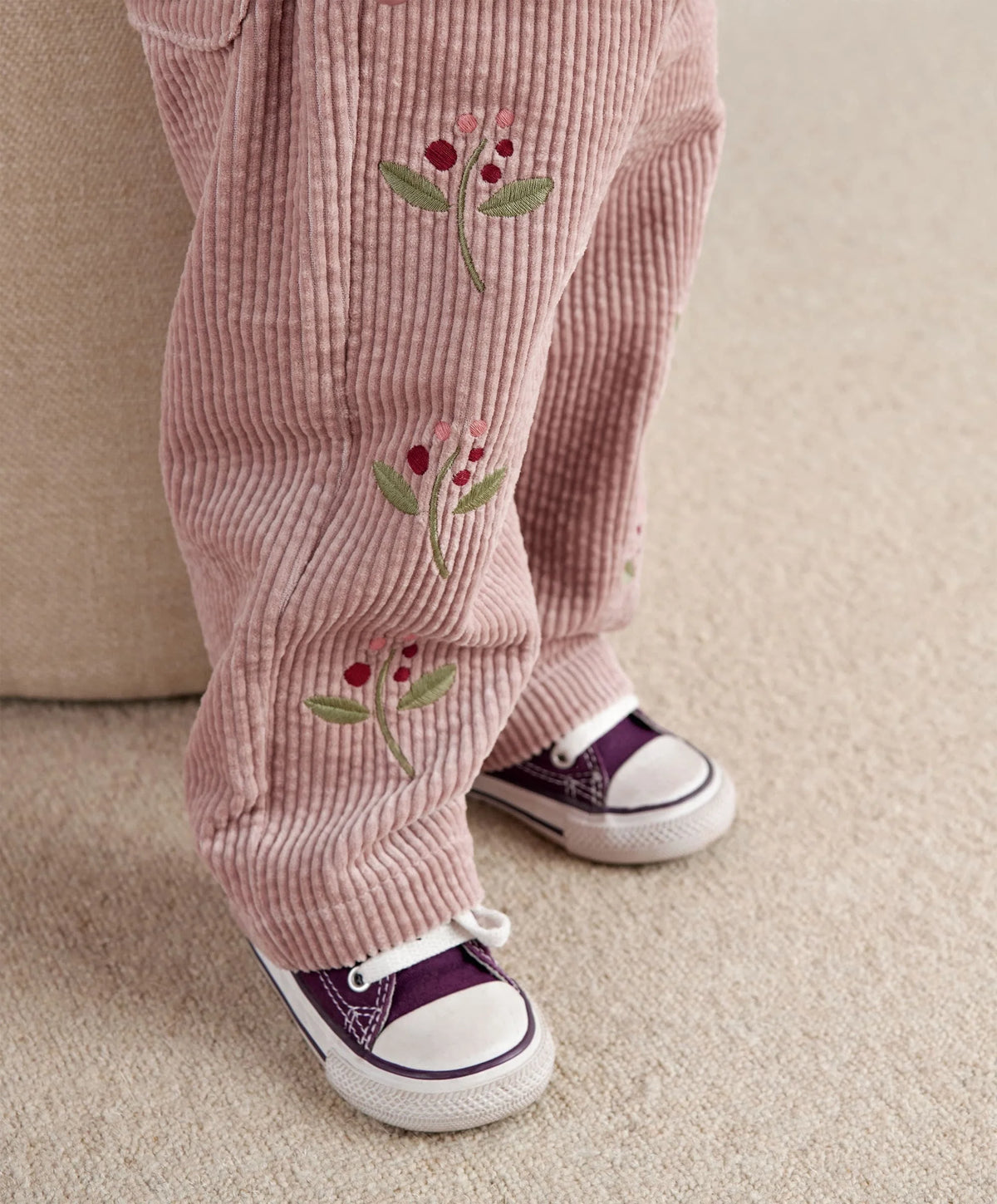 Berry cord trousers with embroidered berry stems, elastic hem cuffs, worn with sneakers