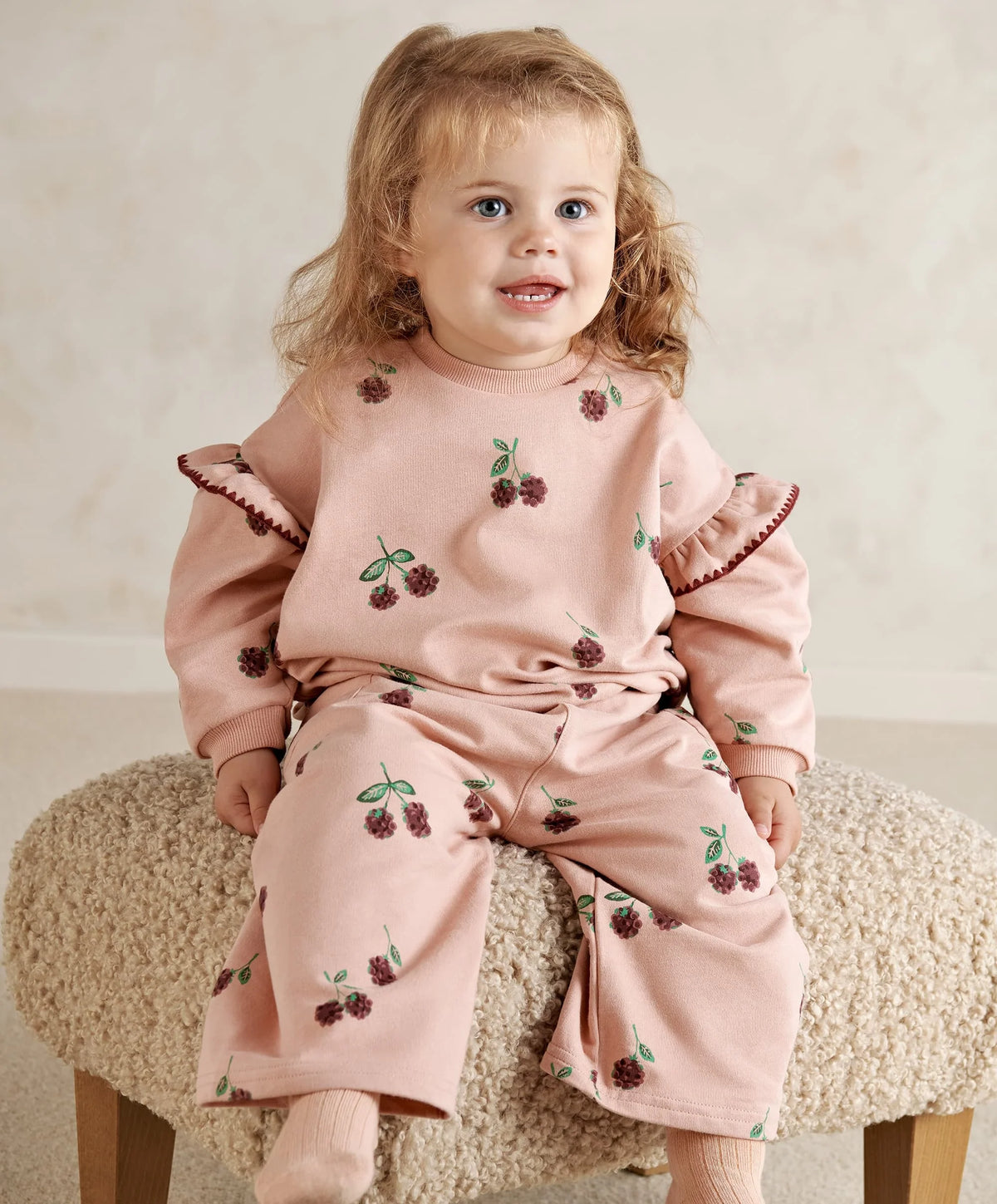 Pink bramble berry printed joggers on a toddler with elastic cuffs