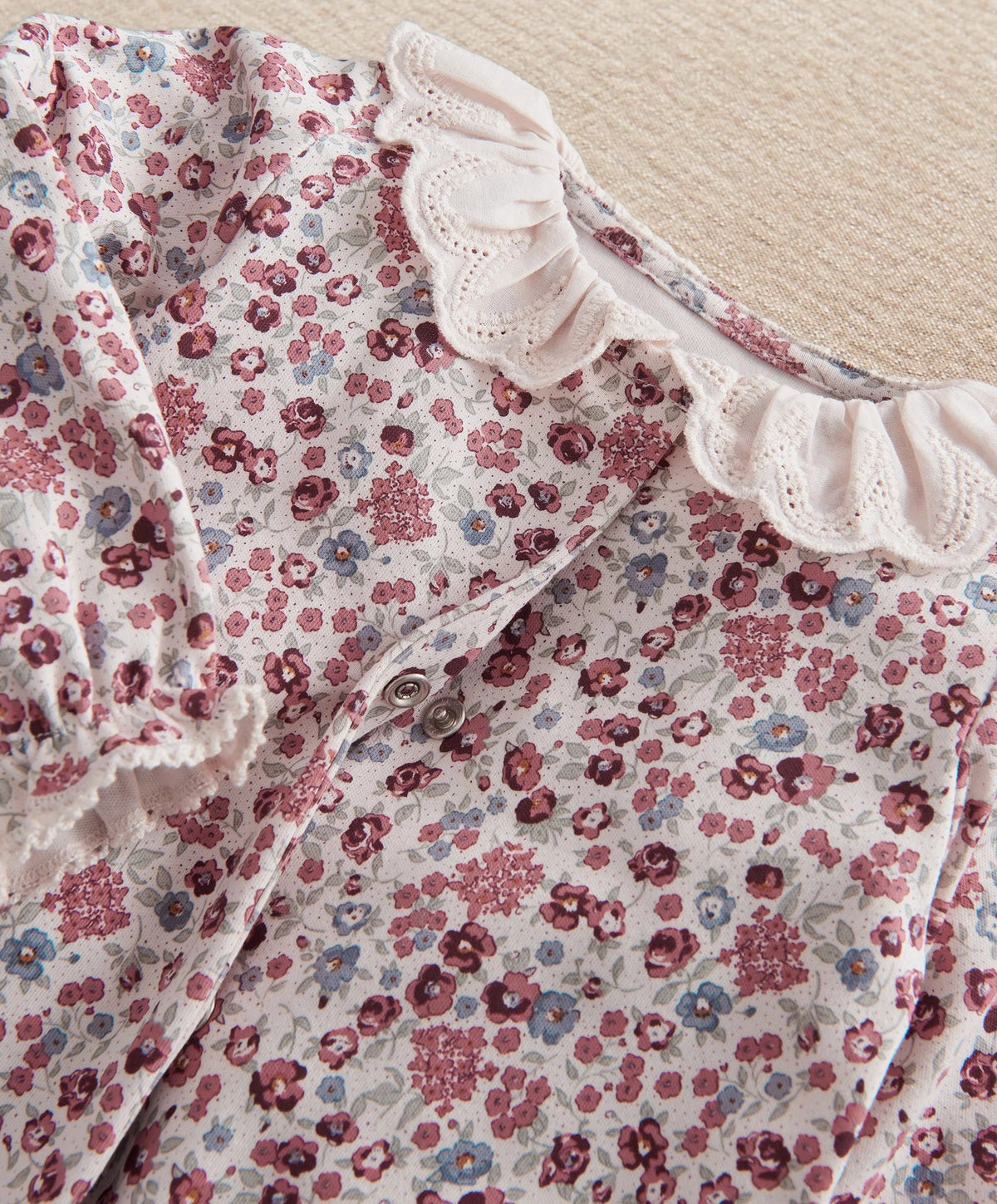 Ditsy floral baby romper close-up of embroidered ruffle collar and buttons