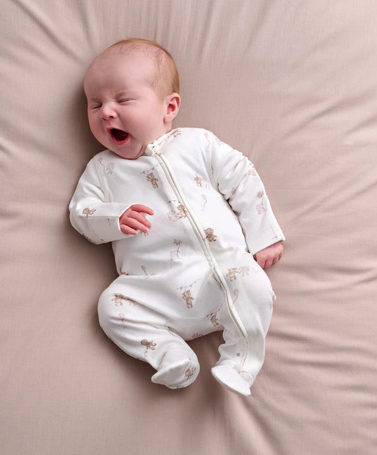 Baby white zip-front all-in-one romper with long sleeves and animal print