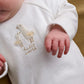 White baby all-in-one with embroidered duck and Hello World text
