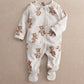 White footed all-in-one romper with brown bear print, long sleeves, snap front.