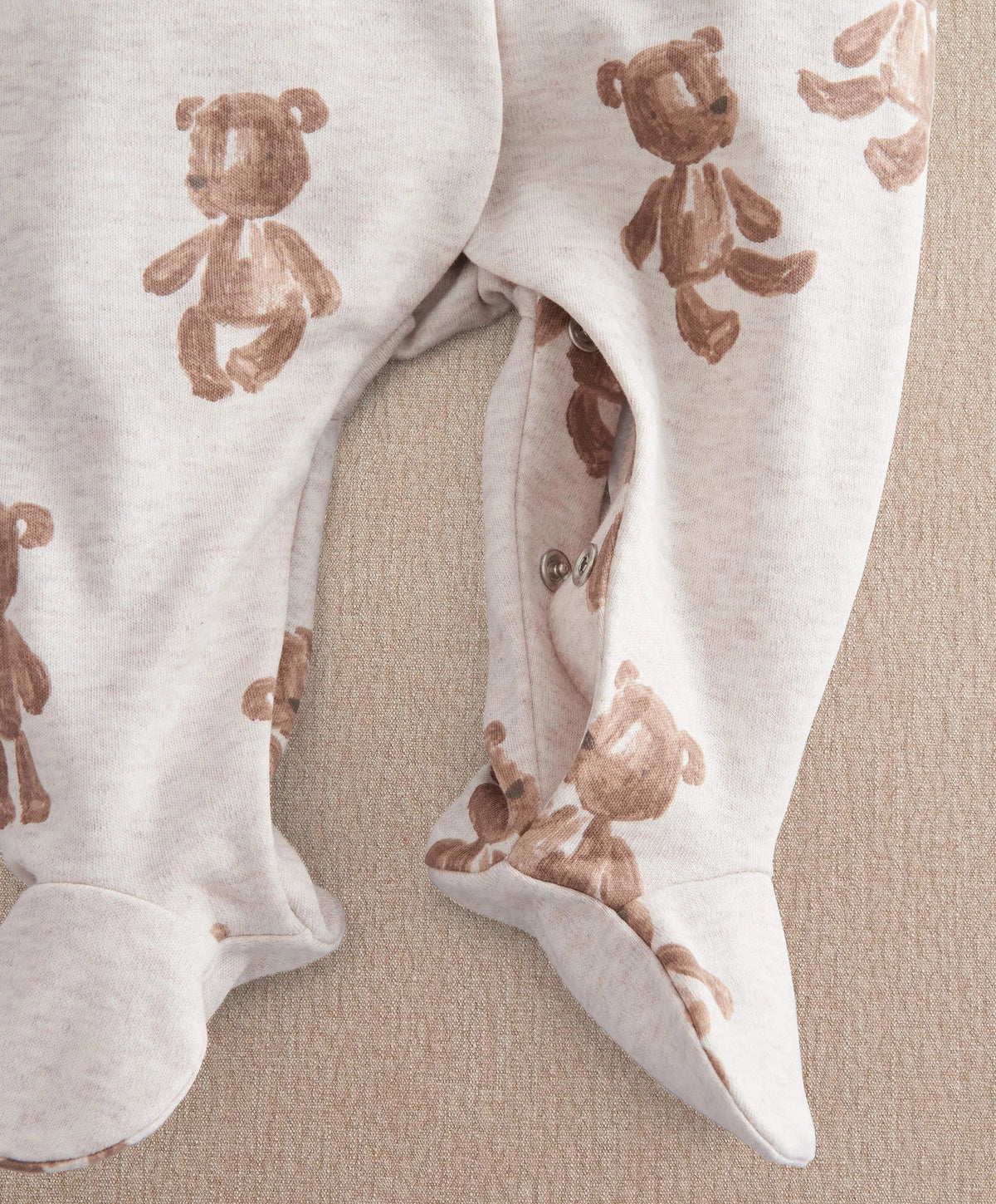 White bear print all-in-one with snap crotch and footed openings at cuffs.