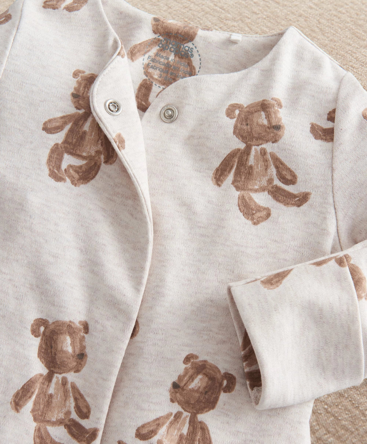 White bear print all-in-one with long sleeves, button front, and bear-pattern cuffs.