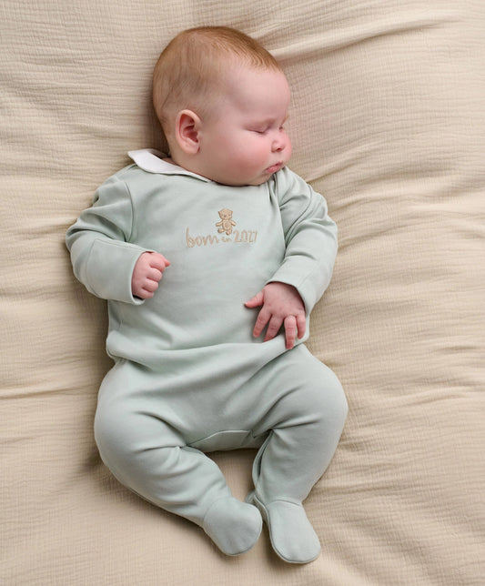 Light blue baby sleepsuit with long sleeves, footed legs, embroidered bear and 2027 text