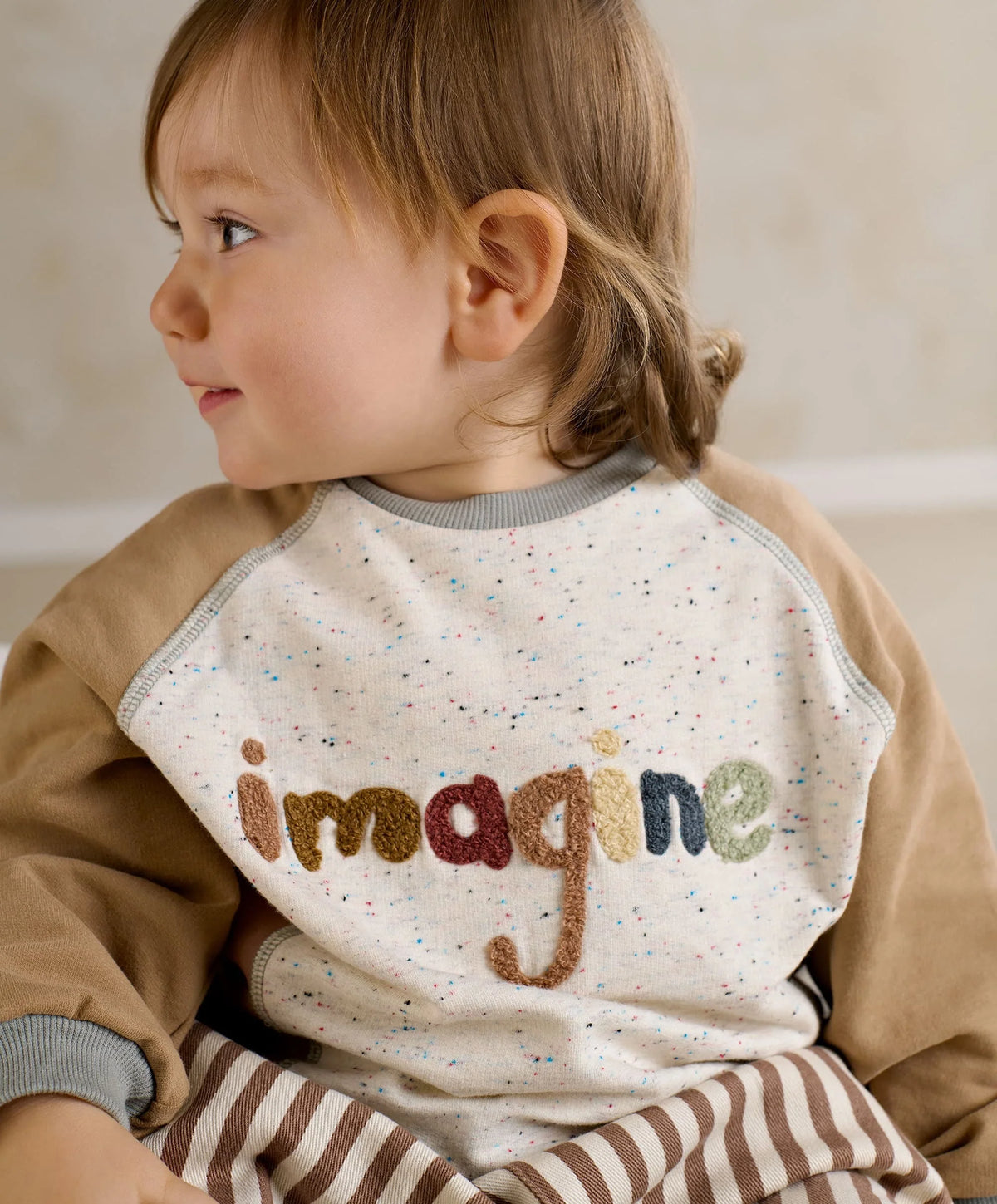 Raglan sweatshirt with 'imagine' logo on speckled white front, beige sleeves, gray collar