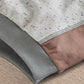 Speckled sweatshirt close-up: gray ribbed cuff and hem with stitched edge