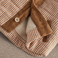 Checked jacket close-up with corduroy sleeves, cozy lining, and snap cuffs