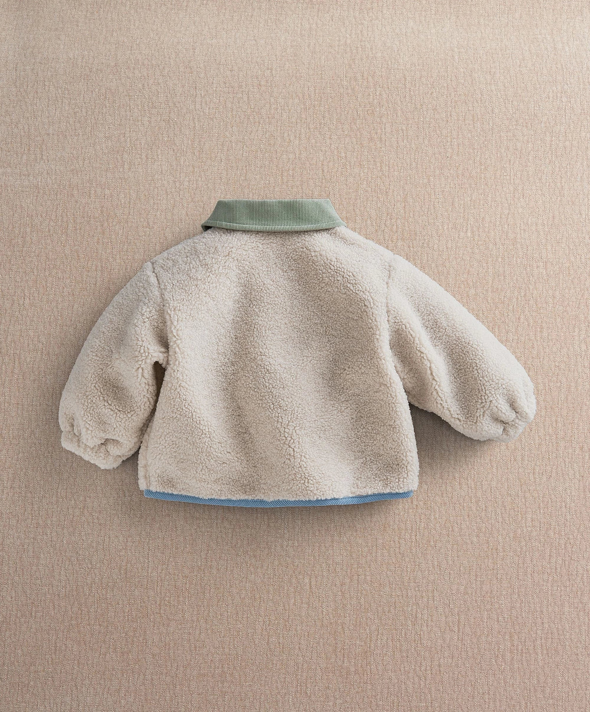 Cream borg jacket back view with mint collar and blue hem trim