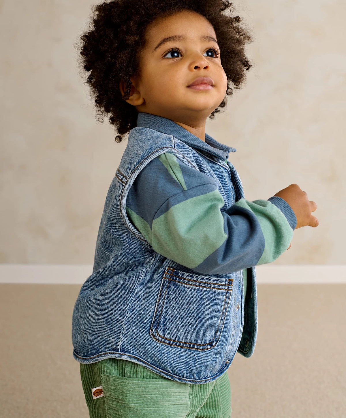 Blue denim sleeveless gilet with stand collar, button front, and chest pockets