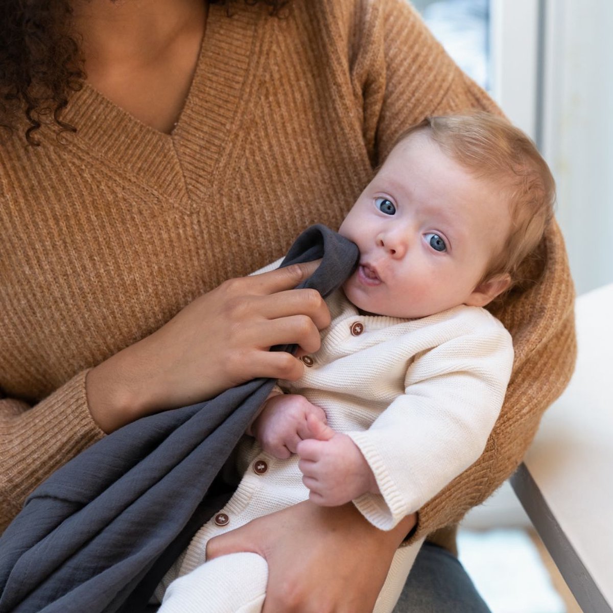 Tetra grey breastfeeding cloth held around a baby at nursing position