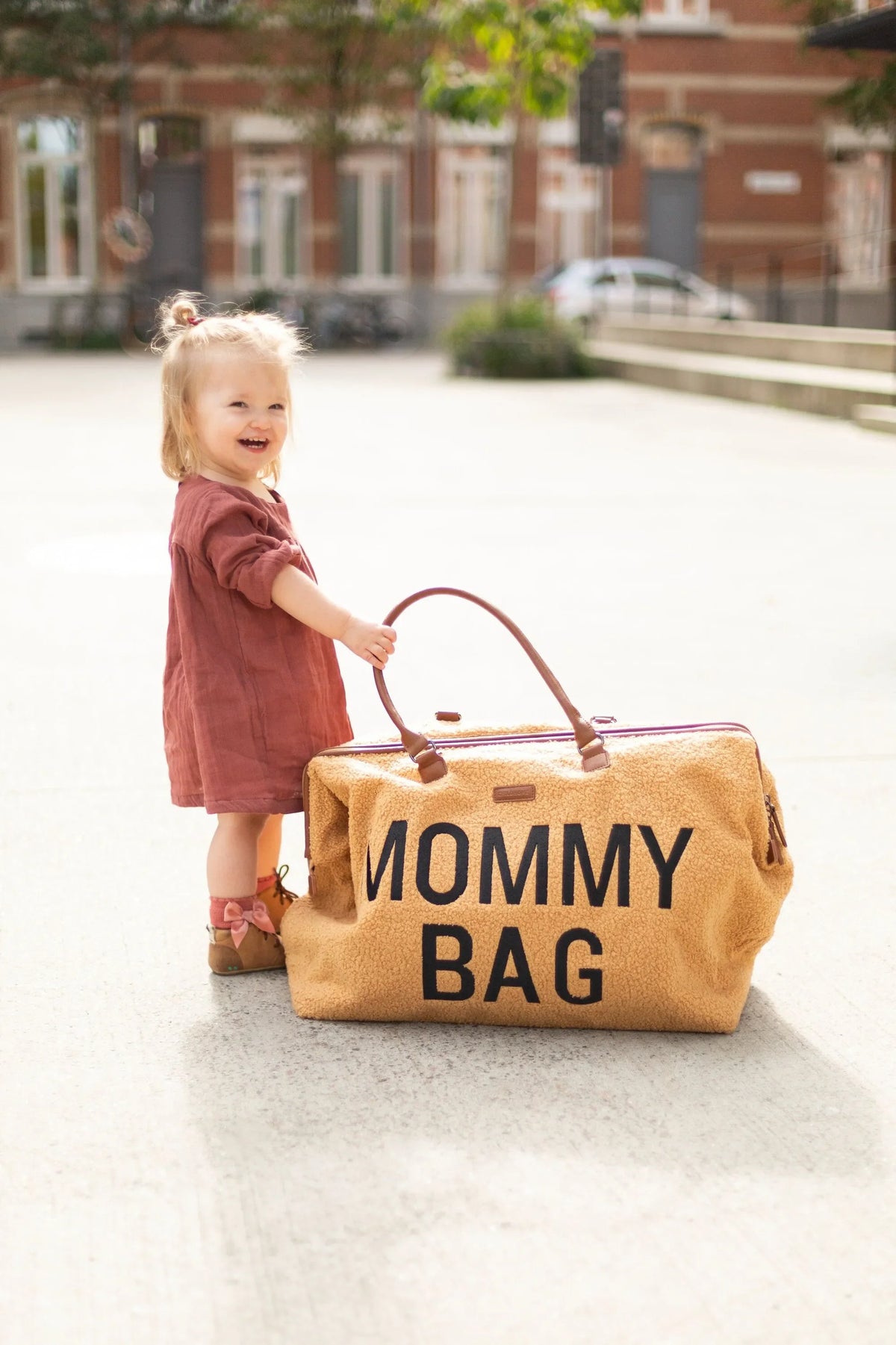 Brown teddy nursery bag with top handles, held by child, 'MOMMY BAG' text