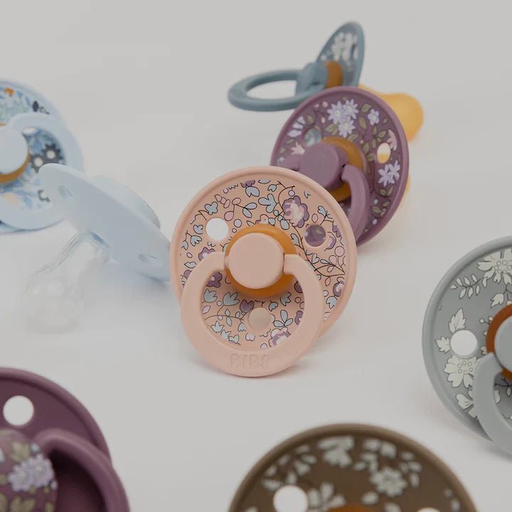 Pacifier set with floral round shields in blue, purple, pink and grey tones